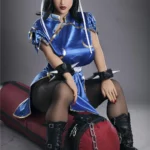 Lylia Sex Doll 158 cm IronTech en tenue bleue, assise sur un sac de frappe, ambiance sportive.