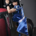 Lylia Sex Doll 158 cm IronTech Doll TPE en tenue cosplay bleue, posant près d'un sac de frappe.