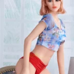 Lylia Sexy 165 cm IronTech Doll TPE en pose debout, vêtue d'un haut fleuri et culotte rouge.