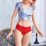 Lylia Sexy 165 cm IronTech Doll en TPE debout, cheveux blonds, top bleu, culotte rouge.