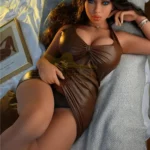 Mélodiea Sex Doll 158 cm IronTech allongée, robe marron, cheveux bruns ondulés.
