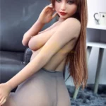 Mirabella Sex Doll 163 cm IronTech en pose assise, regard séduisant, cheveux longs châtains.