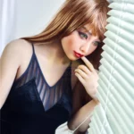 Mirabella Sex Doll 163 cm IronTech en robe noire, regard pensif vers la fenêtre.