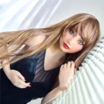 Mirabella Sex Doll 163 cm IronTech en robe noire, posée près de stores blancs.