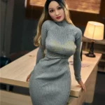 Mirabelle Sex Doll 153 cm IronTech en robe grise moulante appuyée sur un bureau.