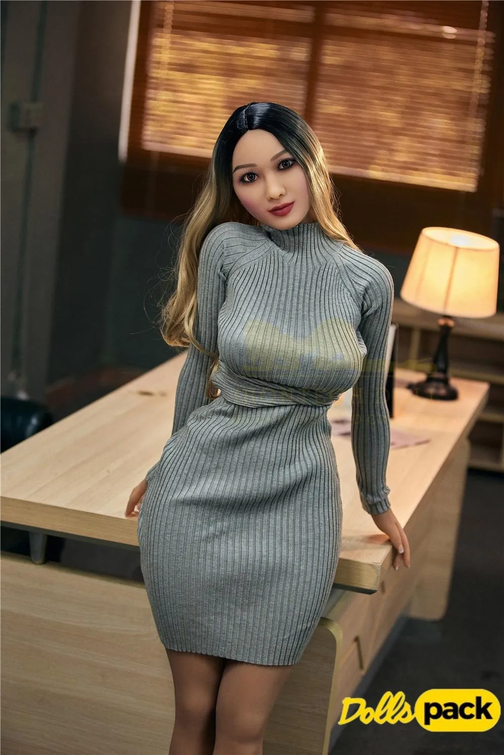 Mirabelle Sex Doll 153 cm IronTech en robe grise moulante appuyée sur un bureau.