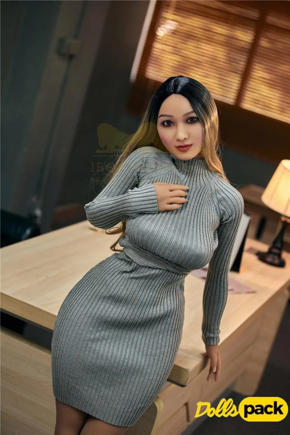Mirabelle Sex Doll 153 cm IronTech en robe moulante grise, posée contre un bureau.