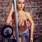 Nimya Sex Doll 163 cm IronTech, pose debout près d'une barre, tenue scintillante et mur de briques.