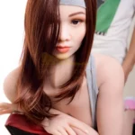 Ondine Sex Doll 168 cm IronTech, cheveux bruns, bandeau gris, pose assise, regard vers l'avant.
