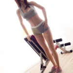 Ondine Sex Doll 168 cm IronTech Doll TPE en tenue de sport, posant sur un banc de musculation.