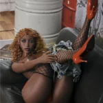 Serenity Real Doll 168 cm IronTech en pose allongée, bas résille, talons rouges, ambiance urbaine.