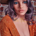Velena Sex Doll 156 cm IronTech avec chapeau de cow-boy, robe orange étoilée, fond brique.