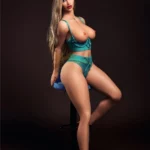 Zelina Sex Doll 164 cm posée sur un tabouret, lingerie turquoise, cheveux longs.