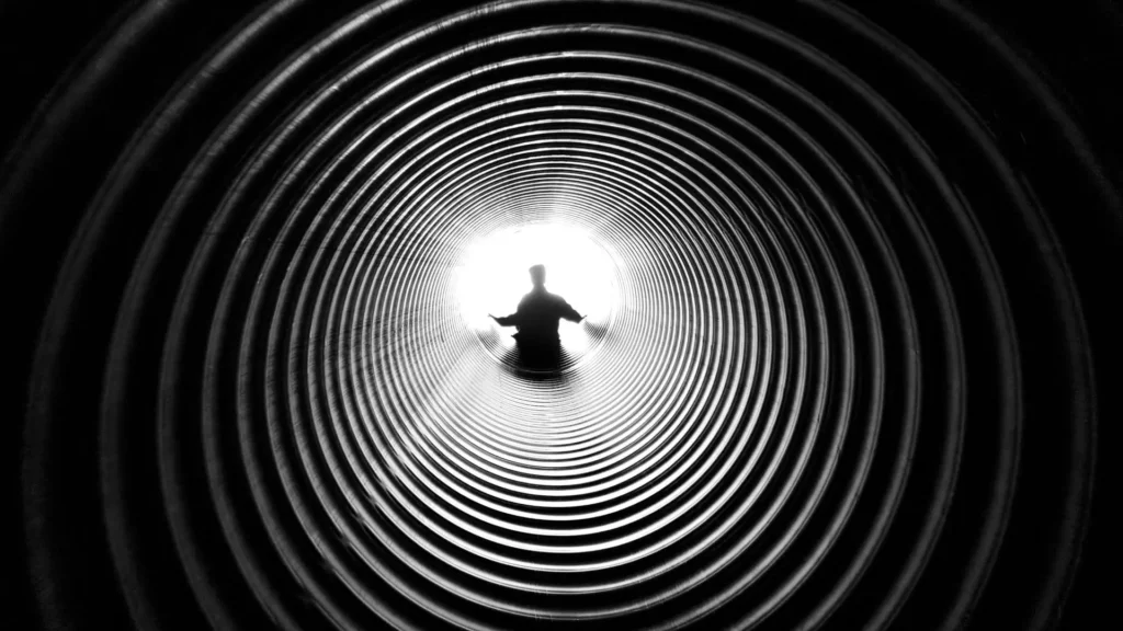 Silhouette d’un homme au bout d’un tunnel symbolisant la recherche d’une solution au problème érectile.